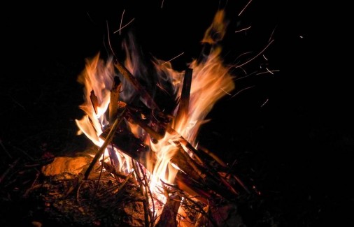 Ein Lagerfeuer wird entzündet bei der Übernachtung im Tipi oder in den Baumzelten