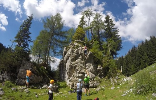 Klettern am Felsen und auf Holzelementen im Klettergarten